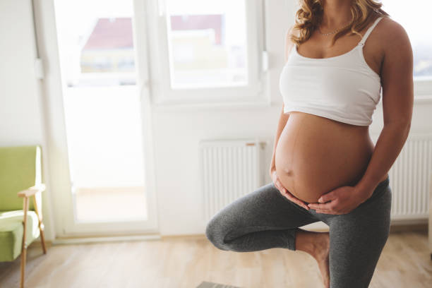 ejercicio de hermosa mujer embarazada en el hogar - human pregnancy yoga exercising prenatal care fotografías e imágenes de stock