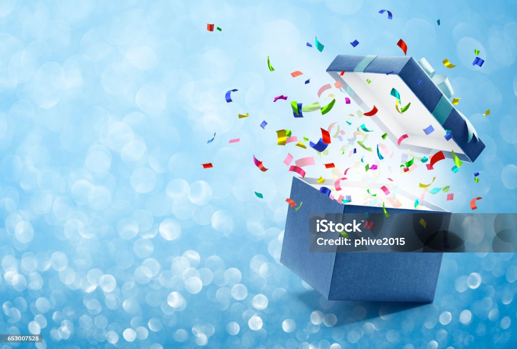 Confetti popping out from gift box Confetti popping out from blue gift box - bokeh background Gift Stock Photo