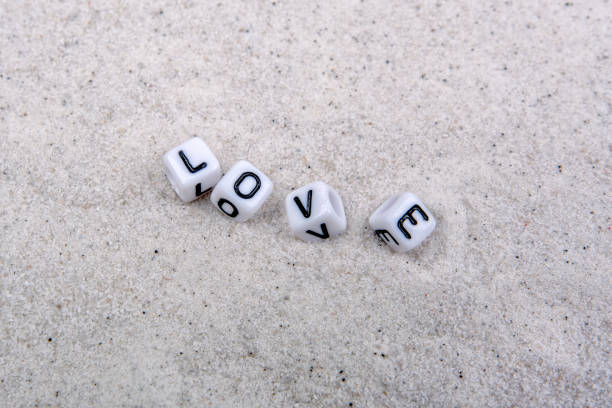 White boxes with love inscription on a grey sand