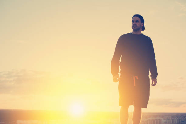 istock Risky man standing on the top of the roof 653014380