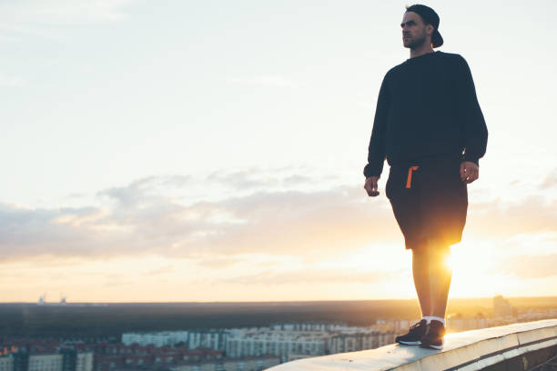 istock Risky man standing on the top of the roof 653014430