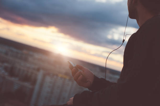 istock Brave man sitting above the city with smartphone 653014532