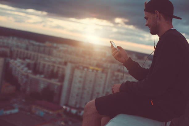istock Brave man sitting above the city with smartphone 653014536