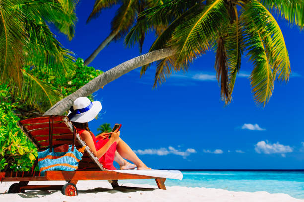 istock remote work concept -woman with touch pad on beach 653014666