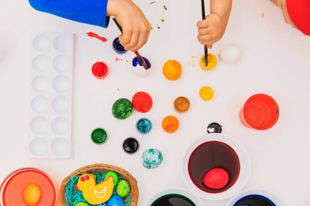 istock little boy and girl painting eggs for easter 653017506