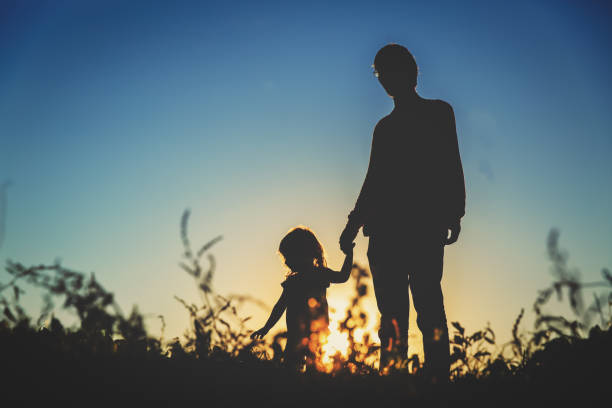 istock father with little daughter walk at sunset 653017942