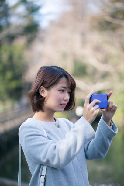 Young woman taking picture on bridge