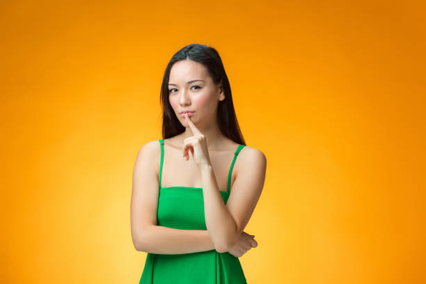 istock The thinking Chinese girl on yellow background 653027016