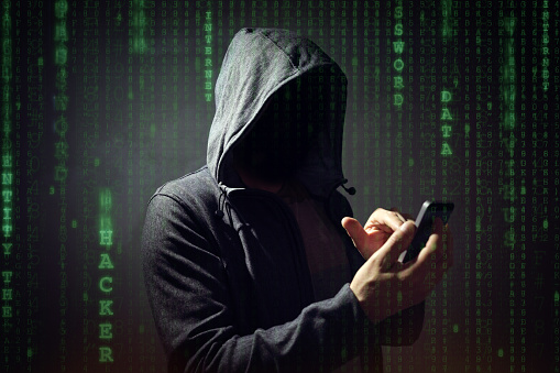 Hacker de computadora con el teléfono móvil photo