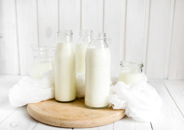 istock Fresh milk in glass bottles on a light wooden background 653030218