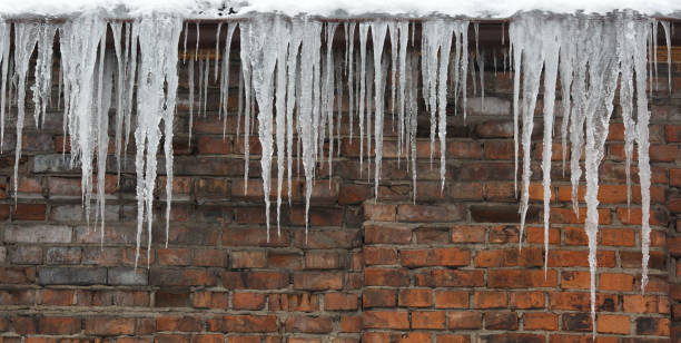 istock Several icicles svesayuschih along the brick wall. 653039436