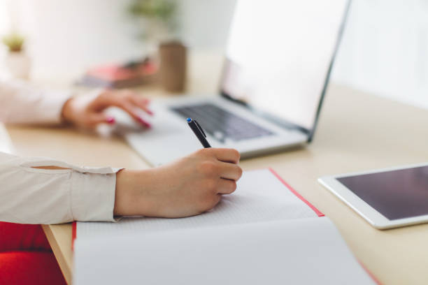 istock Close up student business hand laptop computer notes studying home 653050394
