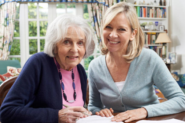 hembra vecino ayudar mujer mayor para completar el formulario - care community 80 plus years cheerful fotografías e imágenes de stock