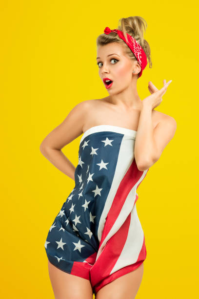 Pin-Up fashion model Sexy blond classic retro style pin-up model wrapped in american flag pics for classic pin up poses stock pictures, royalty-free photos & images