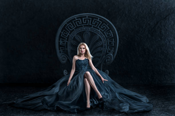 Blonde woman sitting on the throne A woman in a luxurious gown dress sitting on a queen's throne evening gown photos stock pictures, royalty-free photos & images