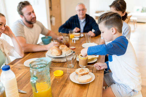 istock Young family having pleasant conversation during breakfast in the dining room 653062100
