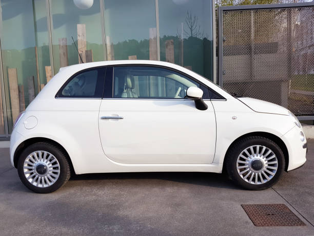 White Fiat 500 White Fiat 500 (Side View) Parked in The Street Of Lyon, France little fiat car stock pictures, royalty-free photos & images