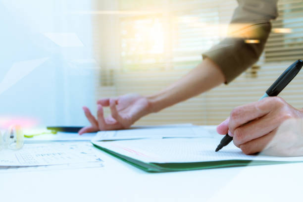 istock business documents on office table and graph business diagram and business people working in the background,business content,business background. 653068996