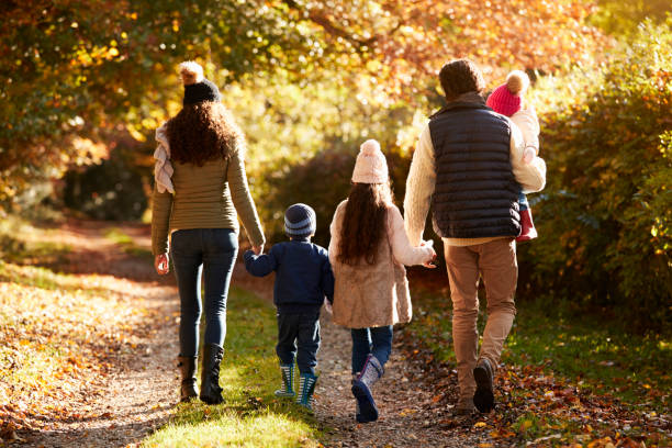 rückansicht der familie genießen herbst-spaziergang in natur - familie mit drei kindern stock-fotos und bilder
