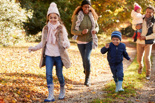 istock Family Running Along Path Through Autumn Countryside 653069478