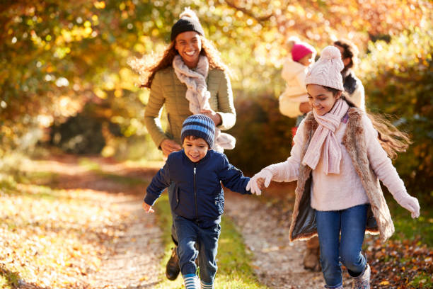 istock Family Running Along Path Through Autumn Countryside 653069486