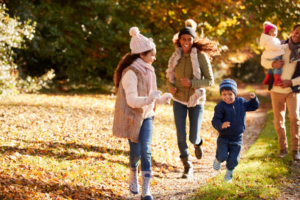 istock Family Running Along Path Through Autumn Countryside 653069490