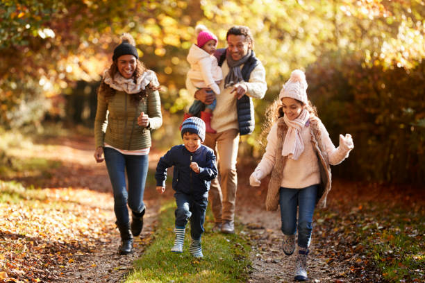 istock Family Running Along Path Through Autumn Countryside 653069492