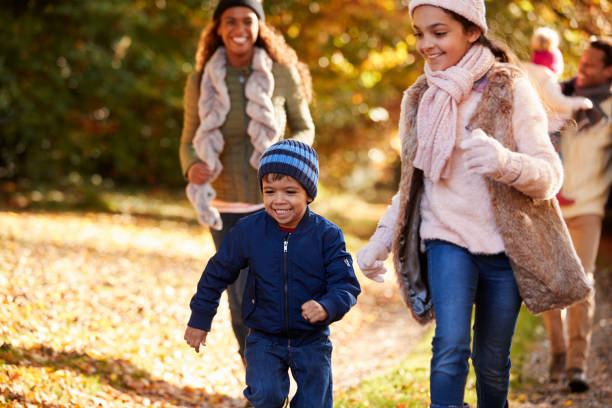 istock Family Running Along Path Through Autumn Countryside 653069508