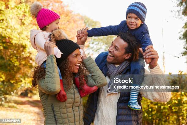 Autumn Walk With Parents Carrying Children On Shoulders Stock Photo - Download Image Now