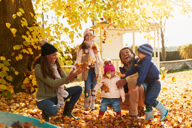 kinder helfen eltern, herbstlaub im garten sammeln - family african ethnicity black african descent stock-fotos und bilder