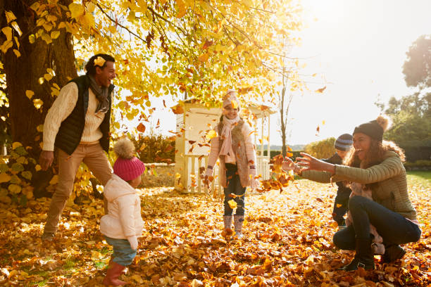 family playing with autumn leaves in garden together - family african ethnicity black african descent imagens e fotografias de stock