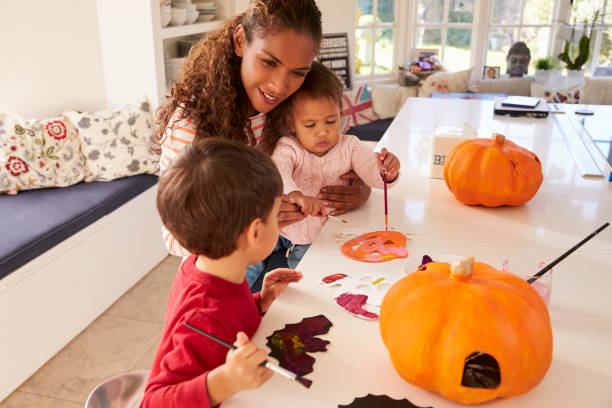 istock Mother And Children Making Halloween Decorations At Home 653072082