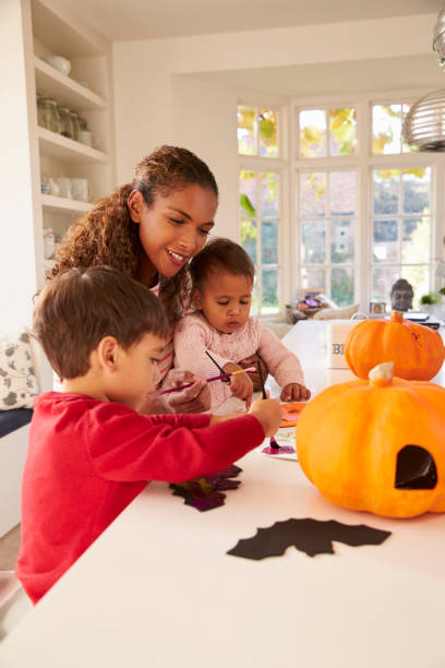 istock Mother And Children Making Halloween Decorations At Home 653072098