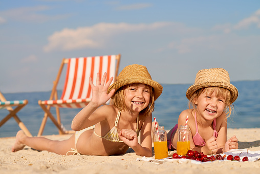 Two little girls sunbathing on the beach