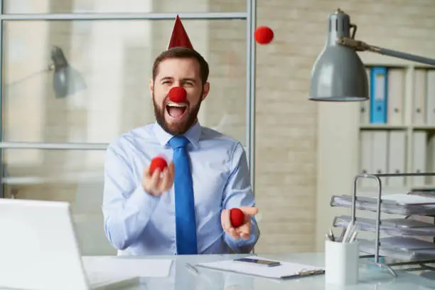 Excited businessman juggling at his workplace