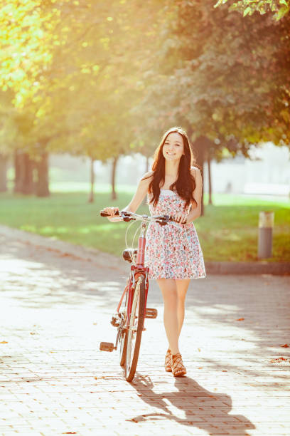 istock The young girl with bicycle in park 653080412