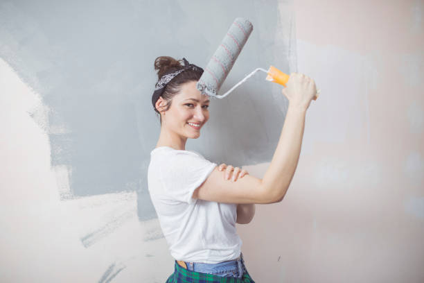 istock Young woman painting walls 653084936