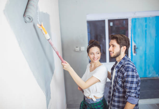 istock Young couple painting walls 653085078