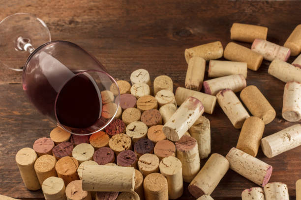 istock Glass of red wine and corks on dark background 653085344