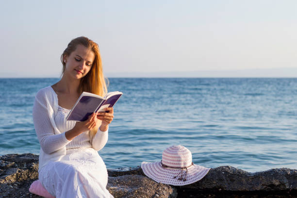 istock Young women reading on beach 653089630