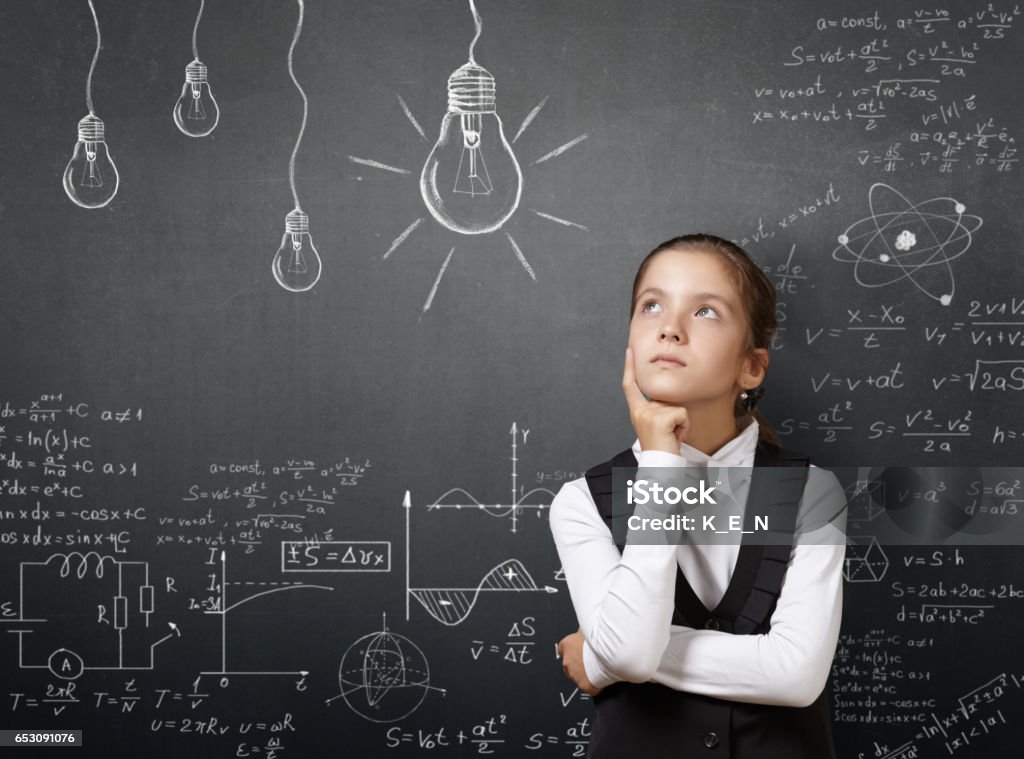 Gifted pretty young girl near blackboard with formulas. Gifted pretty young girl near blackboard with formulas.. Research concept. Child Stock Photo