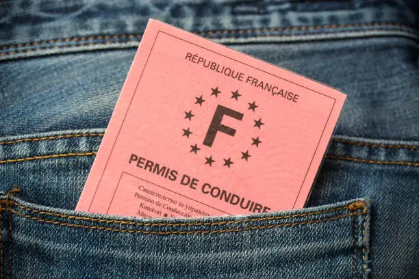 Photo of French driving license in the rear pocket of blue jeans, driving licence test concept