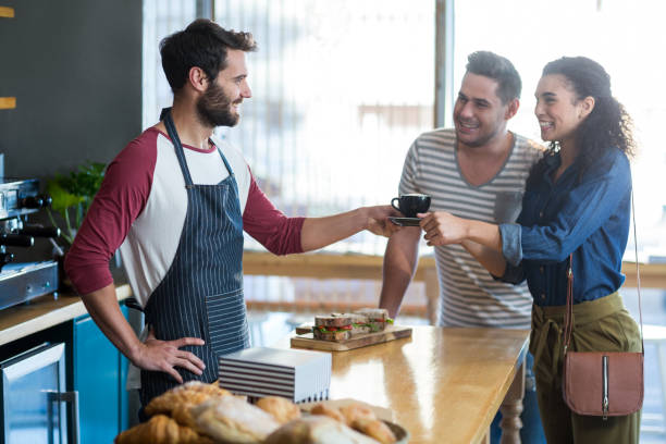 istock Waiter serving a coffee to customer at counter 653097848
