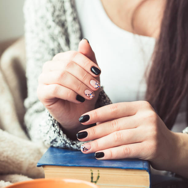 istock Young woman reading book, close-up, on home interior 653097978