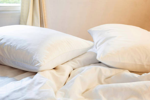 istock white pillow and blanket with wrinkle messy on bed in bedroom with lighting upper left side, from sleeping in a long night winter. 653098626