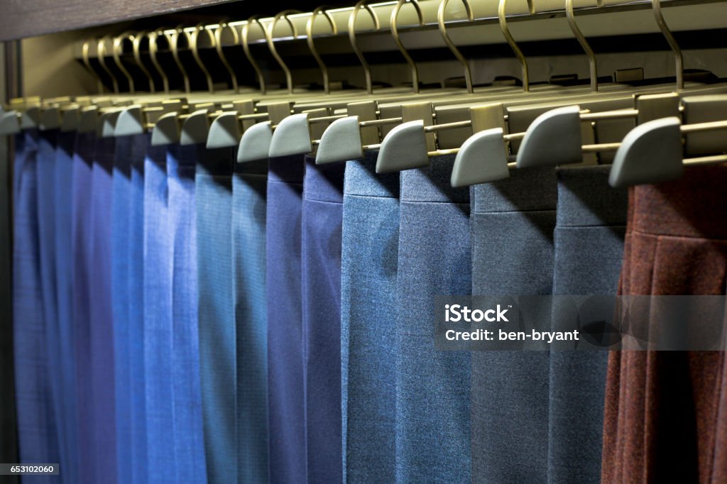 trousers hang on rack Many Pants on hangers in a shop Men Stock Photo