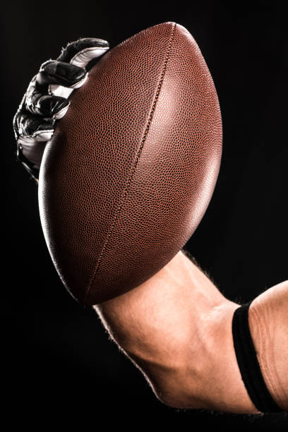 view of hand of football player holding rugby ball - football player imagens e fotografias de stock