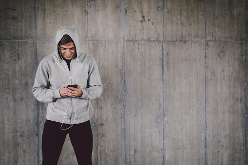 Young man in sportswear using mobile phone