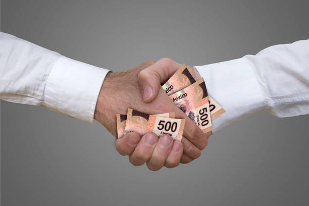 500 pesos bills handshake. 500 pesos bills handshake with grey background. corruption stock pictures, royalty-free photos & images
