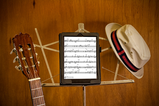 Music stand, tablet, hat and guitar